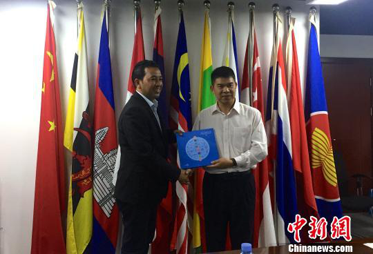 中國(guó)—東盟博覽會(huì)秘書處副秘書長(zhǎng)黃平西（右）與柬埔寨新聞部新聞與傳播總司副總司長(zhǎng)春占皮侖（左）互贈(zèng)禮物。