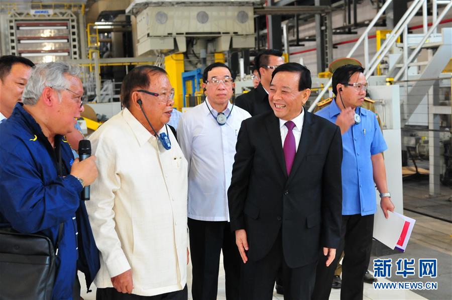 3月10日，在老撾沙灣拿吉省車邦縣，老撾人民革命黨中央總書記、國家主席本揚(yáng)（左二）在山東太陽紙業(yè)股份有限公司董事長李洪信（右二）的陪同下視察公司。 新華社記者章建華攝